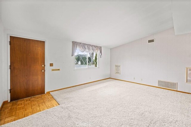 interior space with lofted ceiling, visible vents, and baseboards