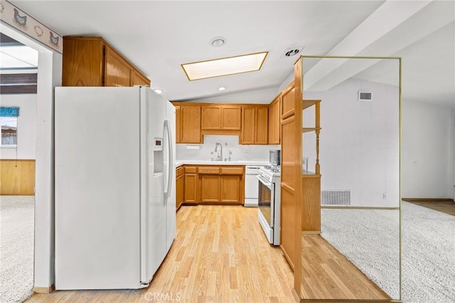 kitchen featuring white appliances, visible vents, vaulted ceiling, and light countertops