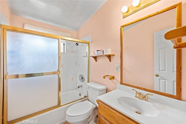 bathroom featuring toilet, combined bath / shower with glass door, and vanity