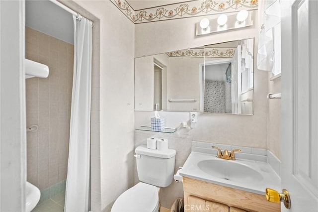 full bath featuring tiled shower, vanity, and toilet