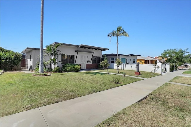 view of front of house featuring a front yard, fence, and stucco siding