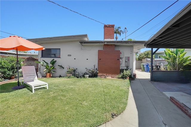 806 W 132nd St, Gardena, CA 90247 - back of property with a chimney, fence, a lawn, and stucco siding