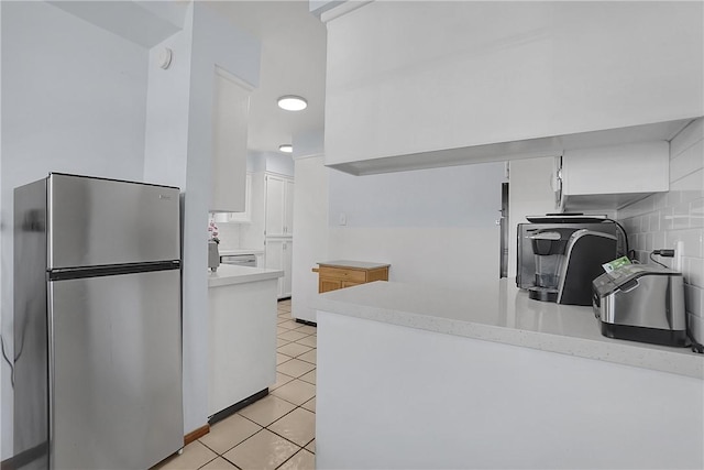 806 W 132nd St, Gardena, CA 90247 - kitchen with light tile patterned floors, white cabinets, decorative backsplash, freestanding refrigerator, and light countertops
