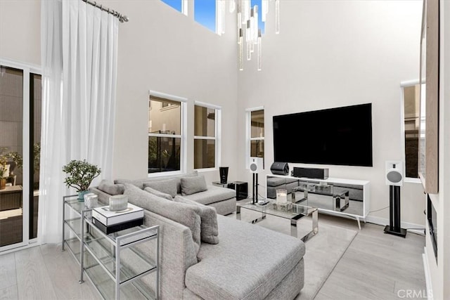 living room featuring baseboards, a high ceiling, and wood finished floors