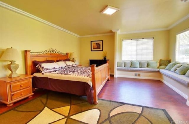 bedroom with wood finished floors and crown molding