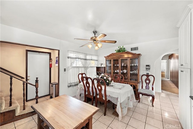 dining area featuring a ceiling fan, arched walkways, visible vents, and light tile patterned floors