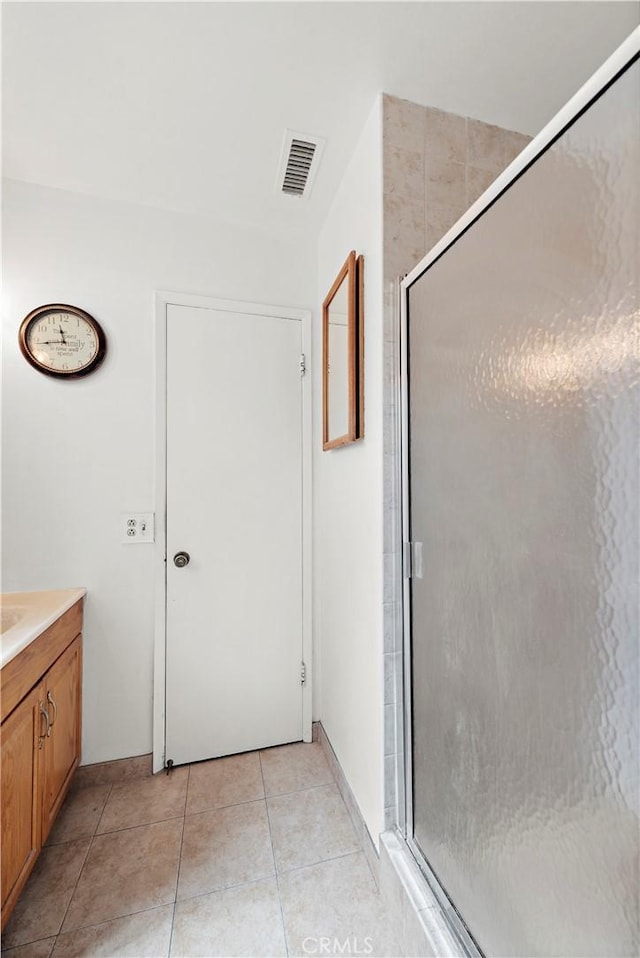 full bath featuring vanity, a stall shower, tile patterned flooring, and visible vents