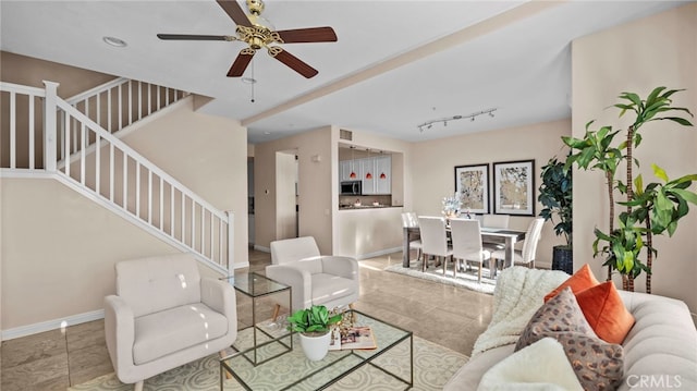 living area with stairway, tile patterned floors, a ceiling fan, and baseboards