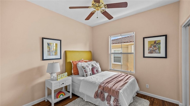 bedroom featuring a ceiling fan, baseboards, and wood finished floors