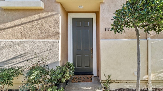 property entrance with stucco siding