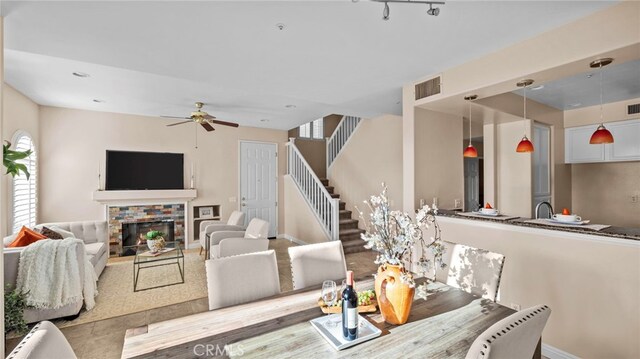 interior space featuring ceiling fan, stairs, visible vents, and a fireplace