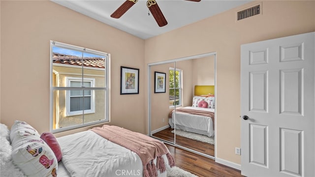 bedroom featuring a closet, wood finished floors, visible vents, and baseboards