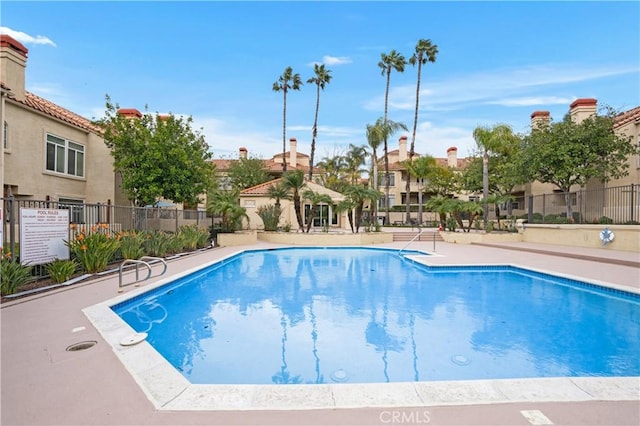 pool with a patio area and fence