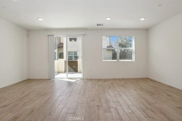 spare room with light wood finished floors, recessed lighting, visible vents, and baseboards