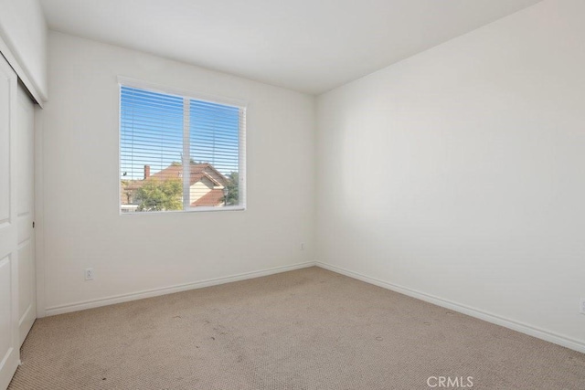 interior space featuring light colored carpet and baseboards