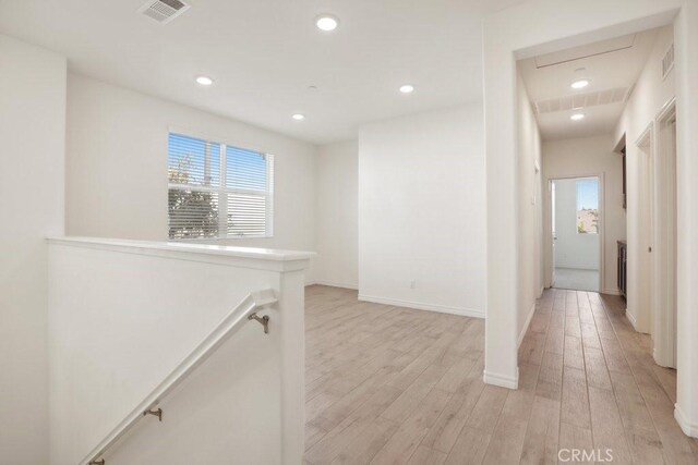 corridor with visible vents, light wood-type flooring, an upstairs landing, and recessed lighting