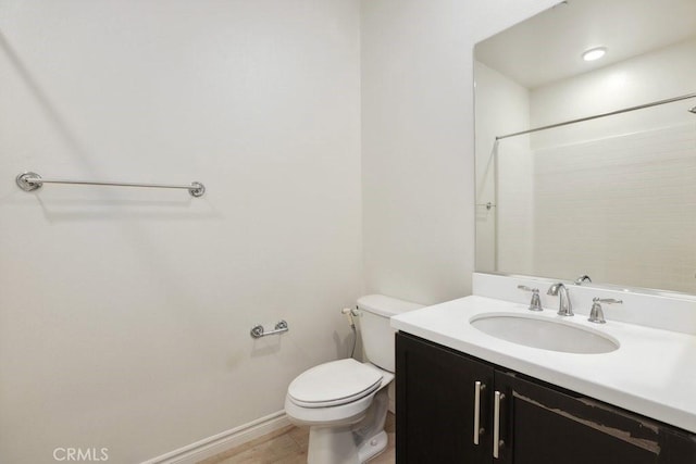 full bath featuring a shower, vanity, toilet, and baseboards