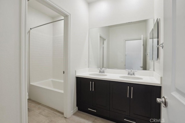 bathroom featuring double vanity, bathtub / shower combination, and a sink