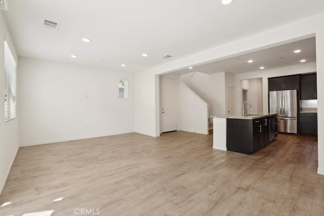 interior space with light wood-style floors, visible vents, a sink, and recessed lighting