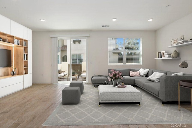 living area featuring recessed lighting, visible vents, and light wood finished floors