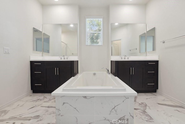 full bath featuring marble finish floor, a garden tub, a sink, and baseboards