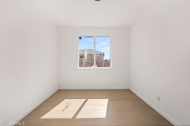 empty room with light wood-style floors and baseboards