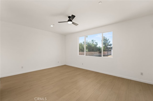 spare room featuring a ceiling fan, recessed lighting, baseboards, and light wood-type flooring