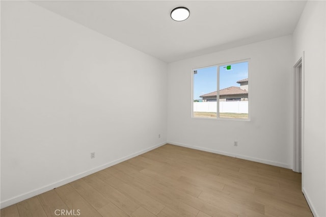 spare room with light wood-type flooring and baseboards