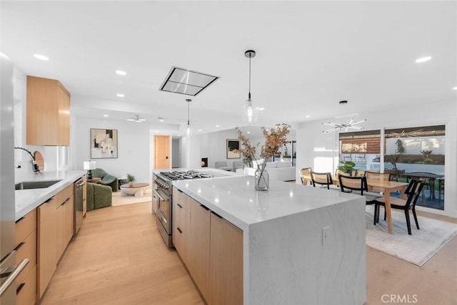 kitchen featuring appliances with stainless steel finishes, open floor plan, a sink, and modern cabinets