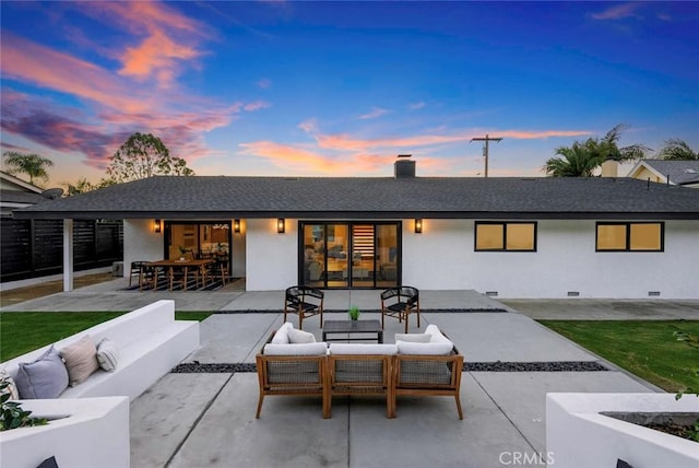 back of house at dusk featuring a patio area, outdoor lounge area, and crawl space