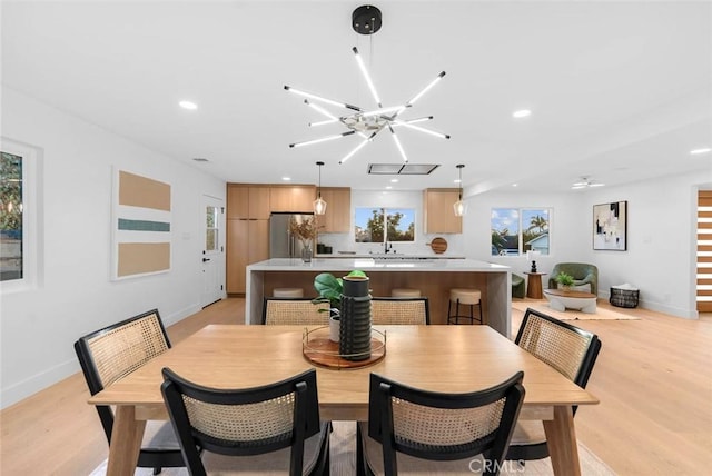 dining space with recessed lighting, plenty of natural light, light wood-style flooring, and baseboards