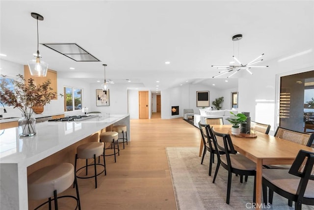 dining area with lofted ceiling, light wood-style flooring, and recessed lighting