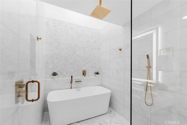 full bath with marble finish floor, a marble finish shower, tile walls, and a freestanding bath