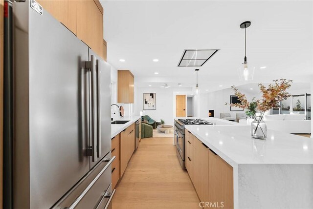 kitchen with open floor plan, modern cabinets, a sink, and high quality appliances