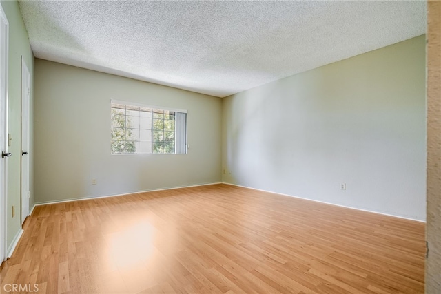 spare room with light wood-style flooring and a textured ceiling