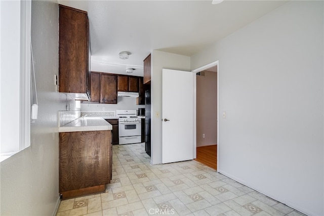 kitchen with light floors, light countertops, dark brown cabinets, white range with gas stovetop, and under cabinet range hood