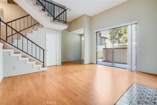 interior space featuring stairway, a high ceiling, and wood finished floors