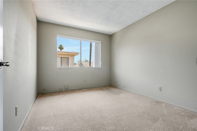 carpeted empty room with a textured ceiling