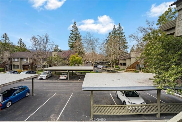 partially covered parking lot featuring a residential view