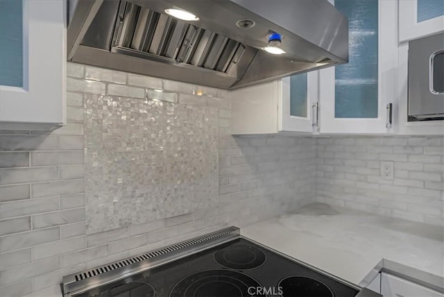 kitchen featuring white cabinetry, ventilation hood, glass insert cabinets, and range