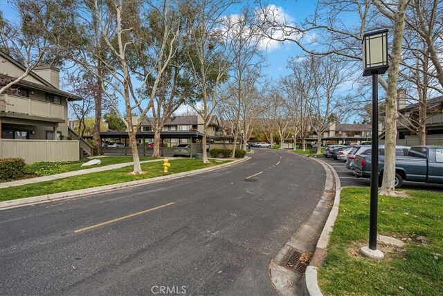 view of road featuring a residential view, curbs, and sidewalks