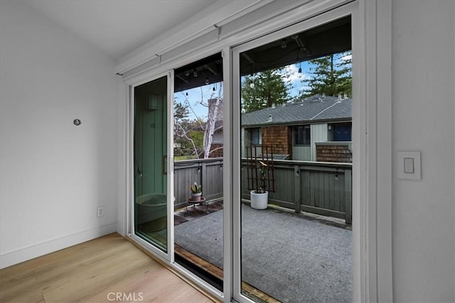 doorway featuring wood finished floors and baseboards