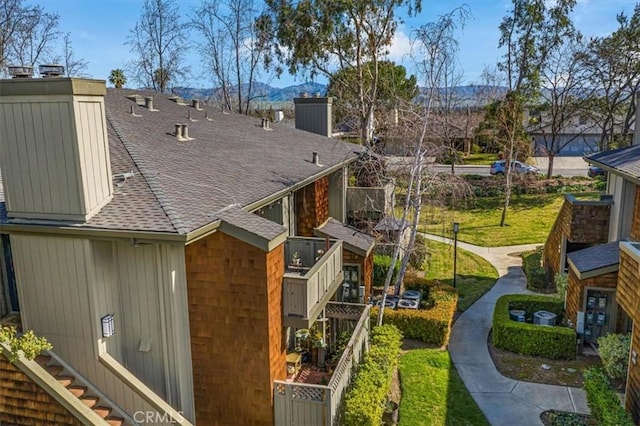 view of side of home with roof with shingles