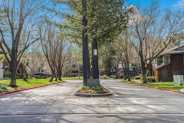 view of street with traffic signs, a residential view, and curbs