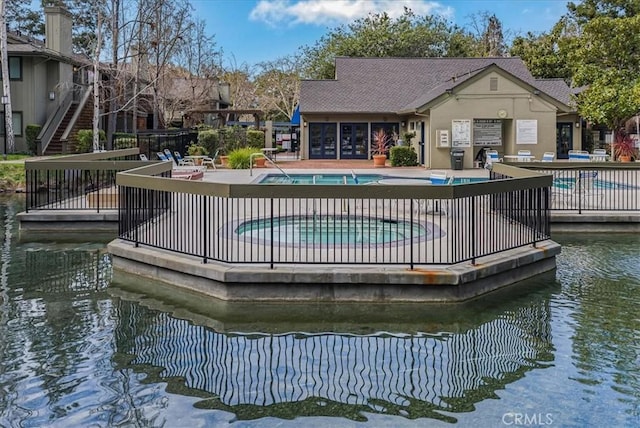 community pool featuring a patio area and a water view