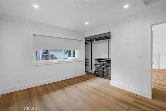 unfurnished bedroom with baseboards, wood finished floors, and crown molding