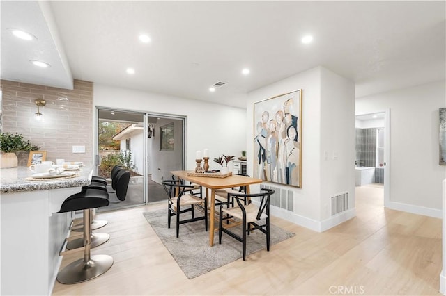 dining area with light wood-style floors, visible vents, and recessed lighting