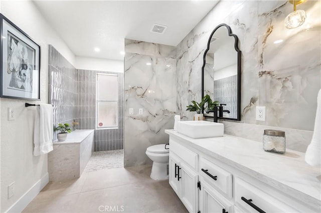 full bath featuring visible vents, toilet, vanity, and tile walls