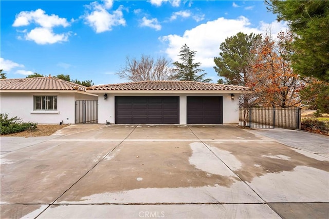 view of front of house with a garage, concrete driveway, a tiled roof, and stucco siding