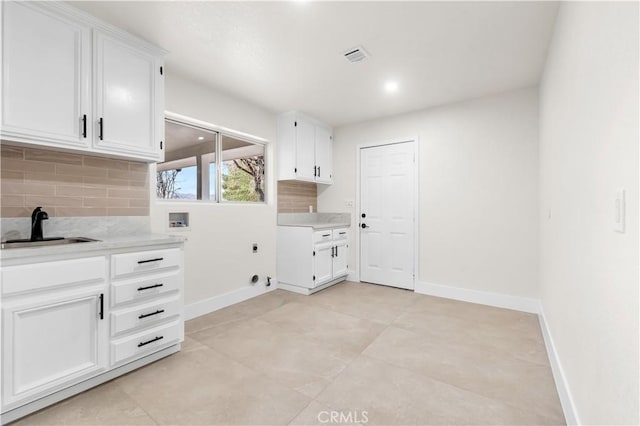 laundry room with washer hookup, cabinet space, hookup for an electric dryer, a sink, and baseboards